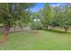 Fenced backyard with mature trees offers privacy and a serene outdoor space at 3713 Highland Creek Dr, Apex, NC 27539