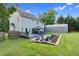 Spacious backyard featuring a deck, patio with fire pit, gazebo, and large storage shelter at 3713 Highland Creek Dr, Apex, NC 27539