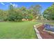 Expansive green backyard with a shed, wooden fence, and tiered landscaping featuring an outdoor seating area at 3713 Highland Creek Dr, Apex, NC 27539