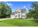 Traditional two-story home with blue shutters, lush green lawn, and a boat parked next to the attached garage at 3713 Highland Creek Dr, Apex, NC 27539