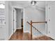 Upstairs hallway with hardwood floors and white trim provides access to bedrooms and bathrooms at 3713 Highland Creek Dr, Apex, NC 27539