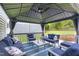 Relaxing covered patio area with comfortable blue seating, stylish cushions, striped rug, and a view of the backyard at 3713 Highland Creek Dr, Apex, NC 27539