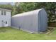 Large gray storage shelter in backyard provides ample space for equipment or vehicle storage at 3713 Highland Creek Dr, Apex, NC 27539
