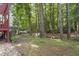 A backyard with a deck, woods, a shed, and a small area for a fire pit at 425 Hidden Cellars Dr, Holly Springs, NC 27540