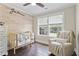 This Bedroom features a crib, chair, beautiful wood wall, and a ceiling fan at 425 Hidden Cellars Dr, Holly Springs, NC 27540