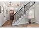 Elegant entryway featuring wood floors, stairs with ornate wrought iron railing, and decorative lighting at 425 Hidden Cellars Dr, Holly Springs, NC 27540