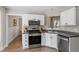 Well-lit kitchen features stainless steel appliances, white cabinetry and gray countertops at 425 Hidden Cellars Dr, Holly Springs, NC 27540