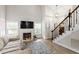 Bright living room showcasing a fireplace, staircase, high ceiling and an open layout at 425 Hidden Cellars Dr, Holly Springs, NC 27540