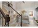 View from stairs into a living room with a fireplace, bright windows, and stylish decor at 425 Hidden Cellars Dr, Holly Springs, NC 27540