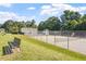 A tennis court beside the pool features a green lawn, fencing, and a nearby bench for relaxation at 425 Hidden Cellars Dr, Holly Springs, NC 27540