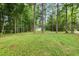 Expansive grassy yard surrounded by tall trees, offering a serene and private outdoor space at 4737 Uzzle Rd, Rougemont, NC 27572
