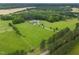 Beautiful property with a long driveway leading to a charming home, nestled among sprawling green fields and mature trees at 4737 Uzzle Rd, Rougemont, NC 27572