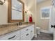 Well-lit bathroom features a granite countertop, decorative mirror, and white cabinets at 4737 Uzzle Rd, Rougemont, NC 27572