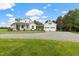 Sprawling two-story home with a well-maintained lawn, a detached garage, and a long gravel driveway at 4737 Uzzle Rd, Rougemont, NC 27572