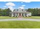 Stunning two-story white home featuring a charming wrap-around porch and a meticulously landscaped front yard at 4737 Uzzle Rd, Rougemont, NC 27572