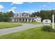 A beautiful two-story white home with charming porch and a 'Thistlewood' sign, set on a large lot at 4737 Uzzle Rd, Rougemont, NC 27572
