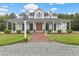 A beautiful two-story white home featuring a charming wrap-around porch and manicured landscaping at 4737 Uzzle Rd, Rougemont, NC 27572