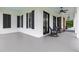 Covered front porch featuring rocking chairs and black french doors overlooking the yard at 4737 Uzzle Rd, Rougemont, NC 27572