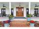 Inviting covered front porch featuring a wooden door, elegant decor, and ample seating at 4737 Uzzle Rd, Rougemont, NC 27572