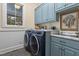 Well-equipped laundry room with modern washer and dryer, marble countertops, and ample cabinet space at 4737 Uzzle Rd, Rougemont, NC 27572