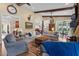 Spacious living room with beamed ceilings, stone fireplace, and ample seating at 4737 Uzzle Rd, Rougemont, NC 27572
