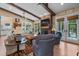 Spacious living room with beamed ceilings, stone fireplace, and access to the outdoors at 4737 Uzzle Rd, Rougemont, NC 27572