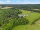 Breathtaking aerial view of a grand estate featuring lush greenery, a pool, and a long driveway at 4737 Uzzle Rd, Rougemont, NC 27572
