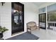 Inviting porch with white siding, a wooden bench, a black front door, and a blue patterned rug at 4737 Uzzle Rd, Rougemont, NC 27572