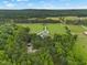 Expansive aerial view showcasing a beautiful home with a long private driveway and lush green surroundings at 4737 Uzzle Rd, Rougemont, NC 27572