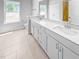 Bright bathroom featuring a double sink vanity with white cabinets, quartz countertop, and a tiled floor at 477 Beacon Hill Rd # 29, Lillington, NC 27546