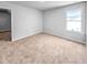 Bedroom featuring neutral carpet, light gray walls, white trim, a window, and a door to another room at 477 Beacon Hill Rd # 29, Lillington, NC 27546