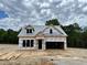 New home construction featuring a two-story design, open garage, and timbered lumber in a partly cloudy setting at 477 Beacon Hill Rd # 29, Lillington, NC 27546