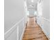 Hallway with hardwood floors and classic wainscoting, connecting to various rooms in the home at 477 Beacon Hill Rd # 29, Lillington, NC 27546