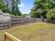 Fenced backyard with large lawn and trees, perfect for recreation at 5012 Silverdene St, Raleigh, NC 27616