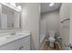 Well-lit bathroom with modern vanity, bathtub with white tile surround and wood-look flooring at 5012 Silverdene St, Raleigh, NC 27616
