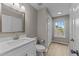 Bathroom with white vanity, brushed gold faucet, and wood look floors at 5012 Silverdene St, Raleigh, NC 27616