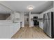 Open kitchen with white cabinets, stainless steel appliances and wood floors at 5012 Silverdene St, Raleigh, NC 27616
