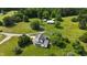 Expansive aerial view of a two-story home with a lush green lawn and outbuildings at 526 Bob Rainey Trl, Burlington, NC 27217