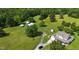 Aerial view of a charming home with outbuildings, surrounded by lush greenery and mature trees at 526 Bob Rainey Trl, Burlington, NC 27217