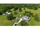 Aerial view of a charming home with lush green landscape, outbuildings, and mature trees at 526 Bob Rainey Trl, Burlington, NC 27217