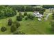 Aerial view of a charming home with lush green landscape, outbuildings, and mature trees at 526 Bob Rainey Trl, Burlington, NC 27217