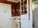 Bathroom with vintage design, pedestal sink, and unique patterned wallpaper at 526 Bob Rainey Trl, Burlington, NC 27217