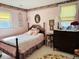 Cozy bedroom with floral wallpaper, a decorative bed, and vintage furnishings at 526 Bob Rainey Trl, Burlington, NC 27217