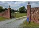 Gated entrance to the property featuring brick pillars with lamps and a decorative iron gate at 526 Bob Rainey Trl, Burlington, NC 27217