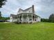 Charming farmhouse with a large wraparound porch and lush green lawn at 526 Bob Rainey Trl, Burlington, NC 27217
