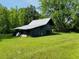Exterior shed view on grassy lot shows tin roof at 526 Bob Rainey Trl, Burlington, NC 27217