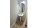 Small powder room with tiled flooring, a pedestal sink, and an oval mirror at 6005 Namozine Ct, Raleigh, NC 27610