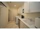 Bright laundry room features white cabinetry, tile flooring, and modern washer and dryer at 615 Sampson St, Raleigh, NC 27609