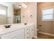 Bathroom with dual sinks, white cabinets, large mirror, and shower/tub combo at 67 Bornean Dr, Garner, NC 27529
