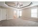 Large bedroom with tray ceiling, neutral carpet, and doorways to the bathroom at 67 Bornean Dr, Garner, NC 27529